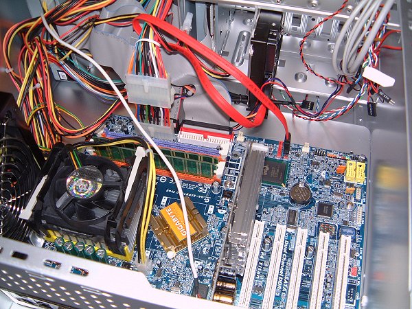 [写真：DVDドライブのケーブルを接続する作業。]